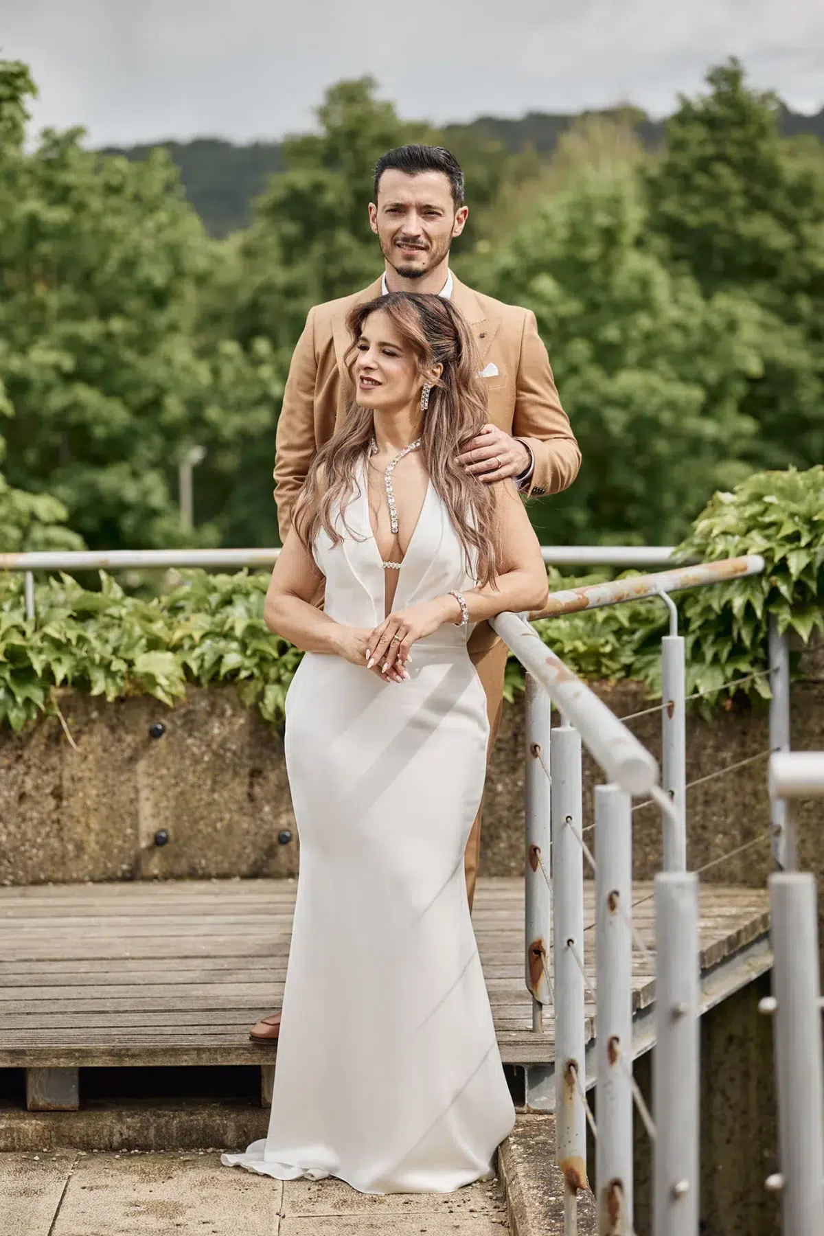 Newlyweds share a quiet embrace on an ivy-lined terrace during their wedding day portraits in Luxembourg.