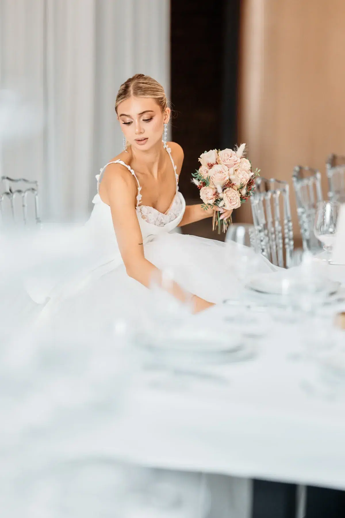 Bride in her wedding gown adjusting the place setting at a beautifully styled reception table, Luxembourg wedding photography.