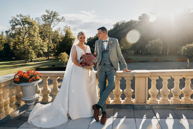 Bride and groom portrait on the terrace balustrade at Château du Bois d'Arlon