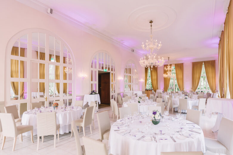 Reception hall set for a wedding dinner with chandeliers at L'Orangerie, Mondorf-les-Bains