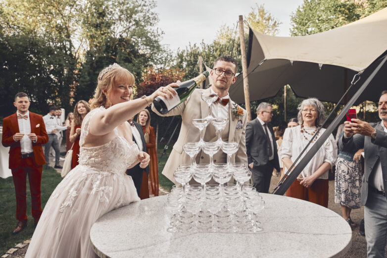 Bride and groom pouring a champagne tower at their wedding reception at Schengener Haff, Luxembourg